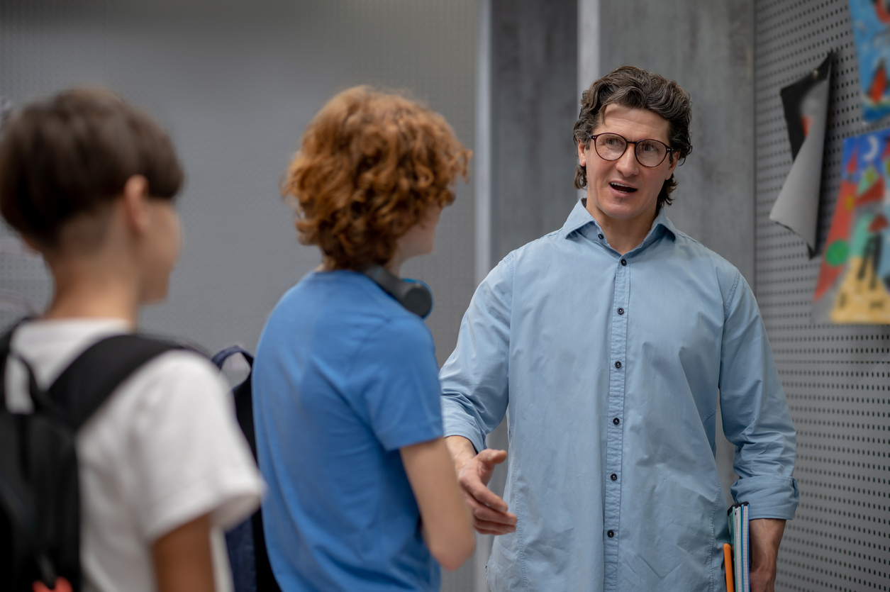 A senior educator talking with students